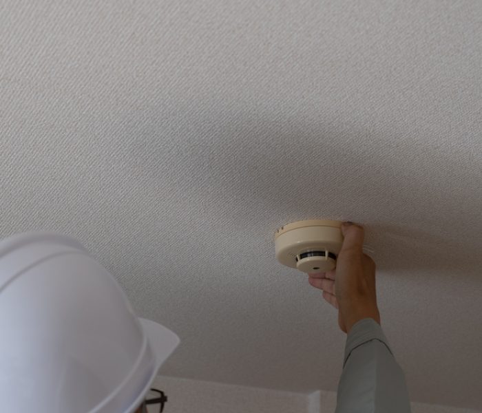 A worker who inspects a fire alarm